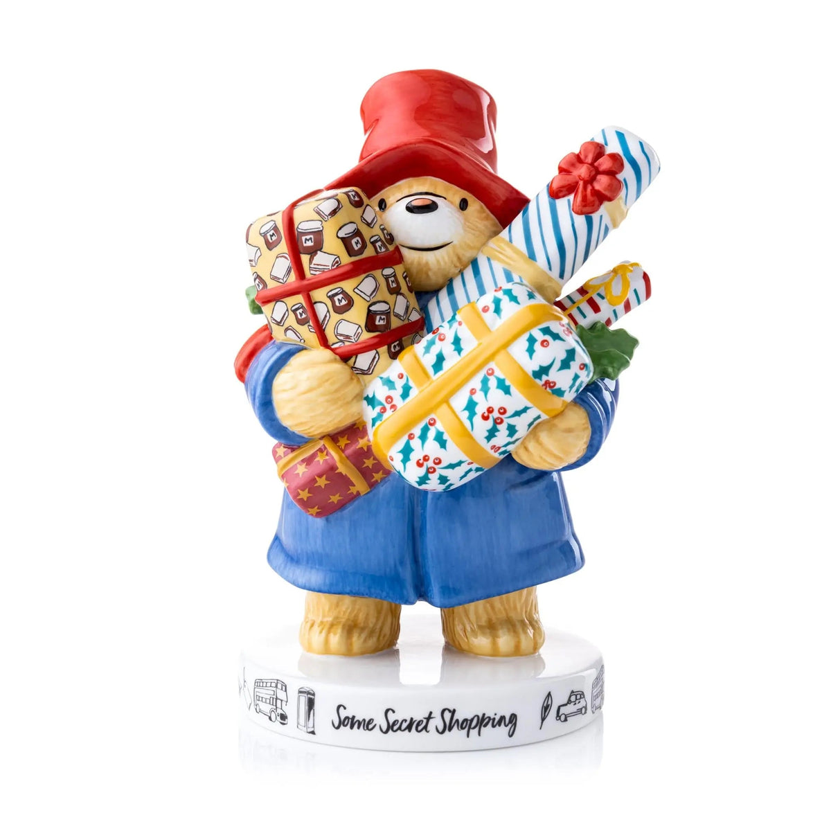 Fine bone china figurine: bear in blue coat and red hat holding striped shopping bag.