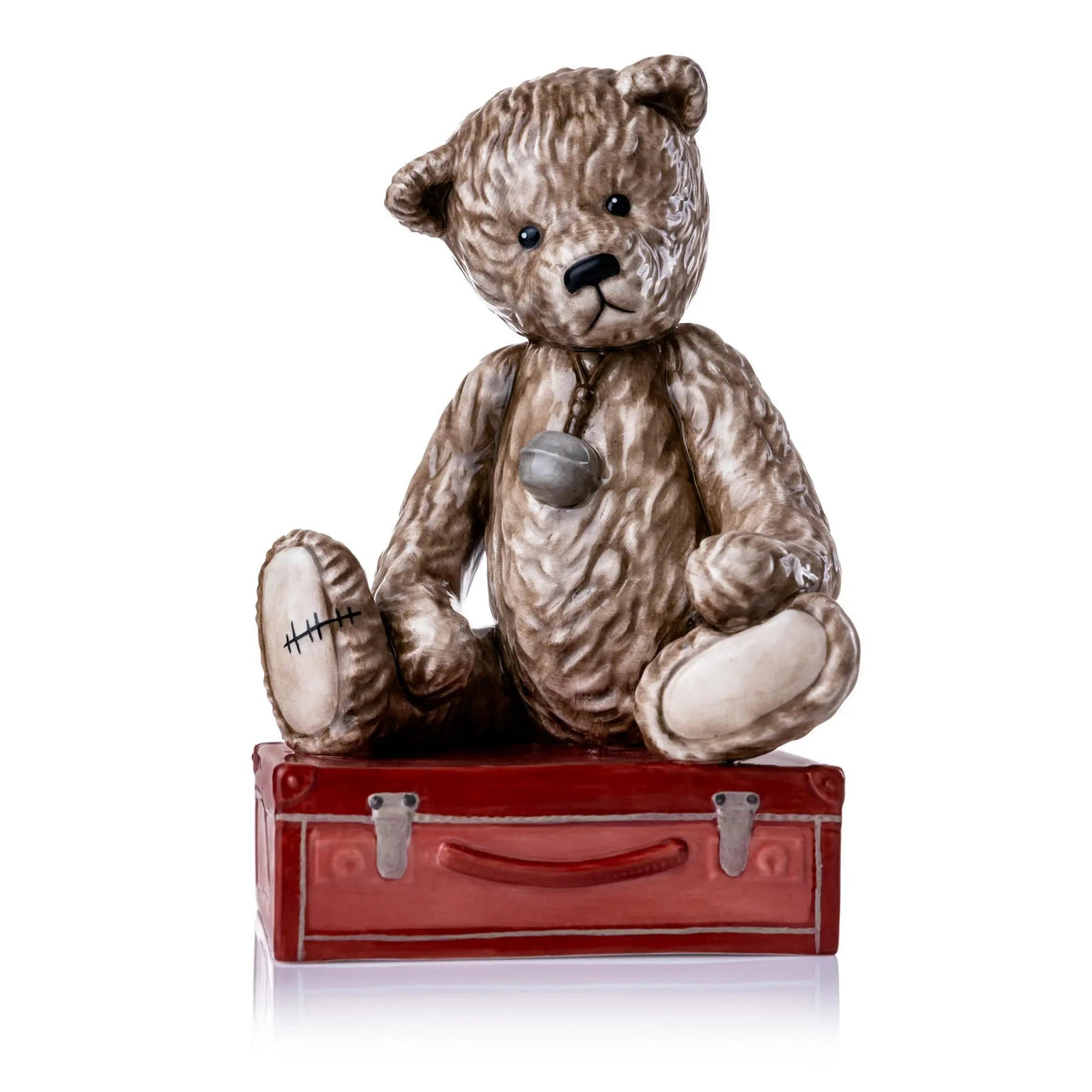 Sitting brown teddy bear figurine with red suitcase, ceramic details
