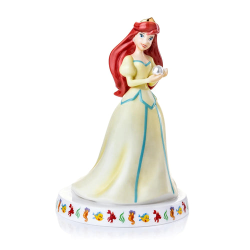 Ariel fine bone china figurine in pale yellow dress with blue trim, holding a seashell