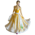 Porcelain female figurine in yellow off-shoulder dress with flowing white flared skirt and purple accents